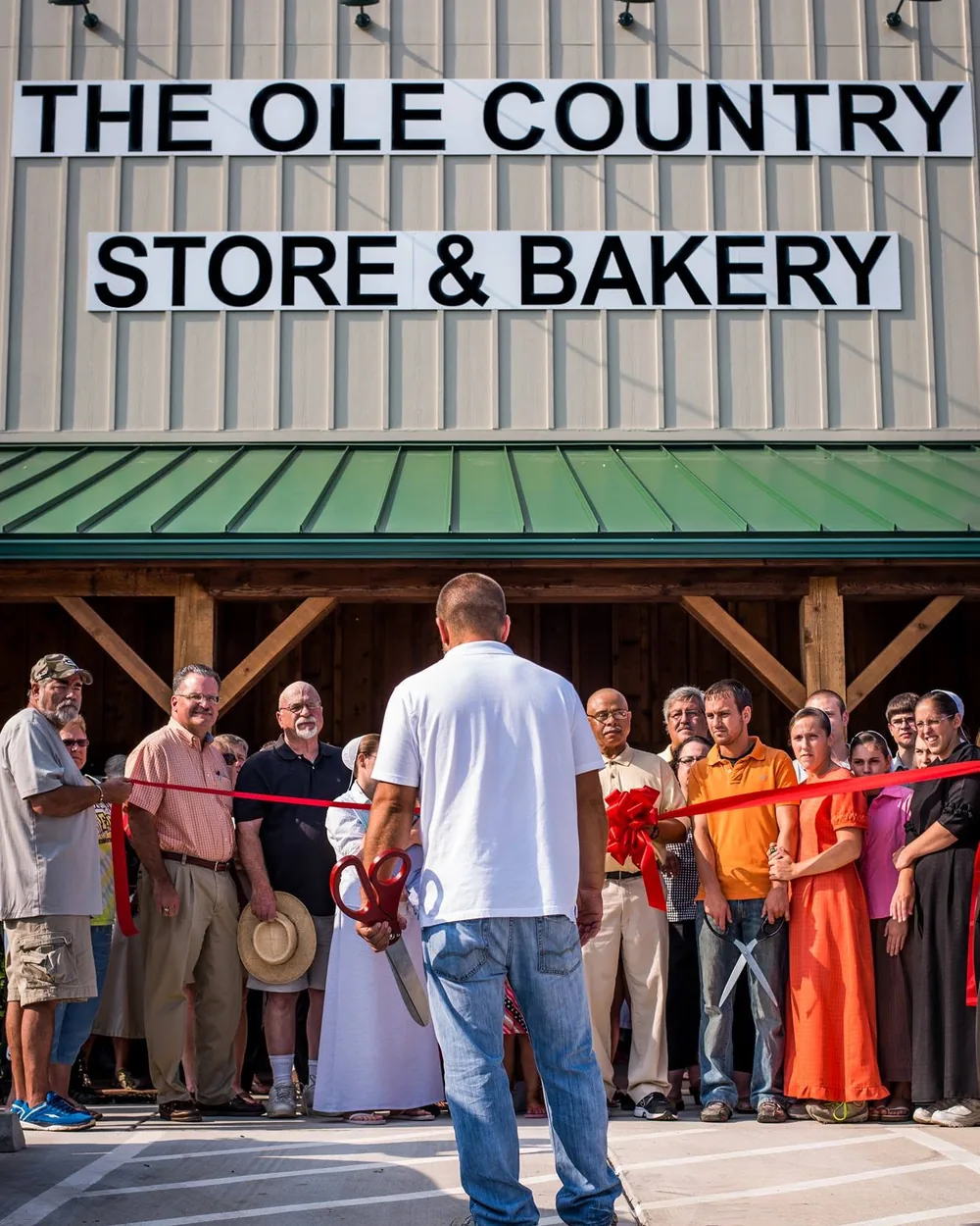 The ribbon cutting on opening day in 2014, with a crowd lined up under the store's new sign